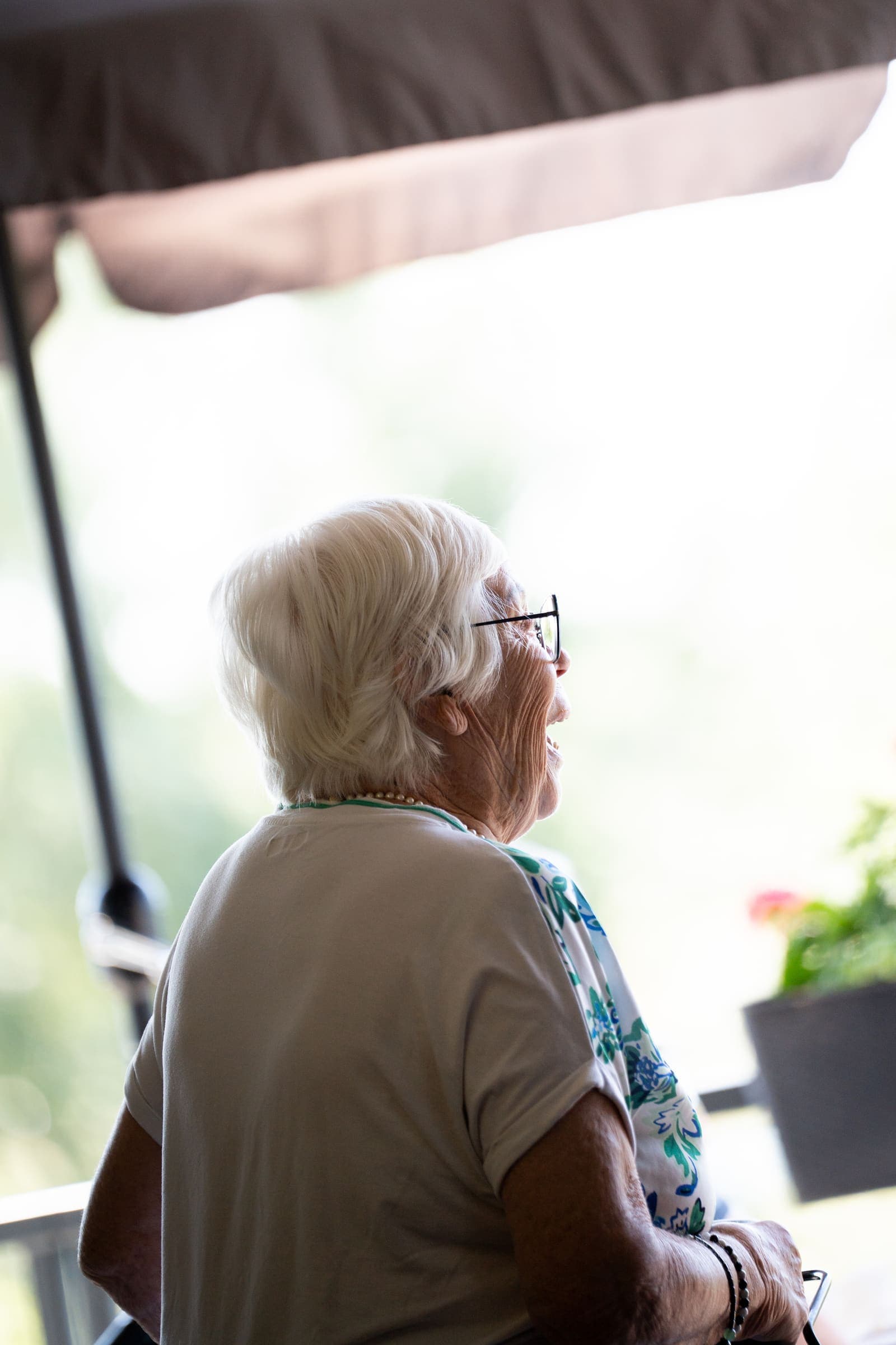 Seniorin schaut aus dem Fenster