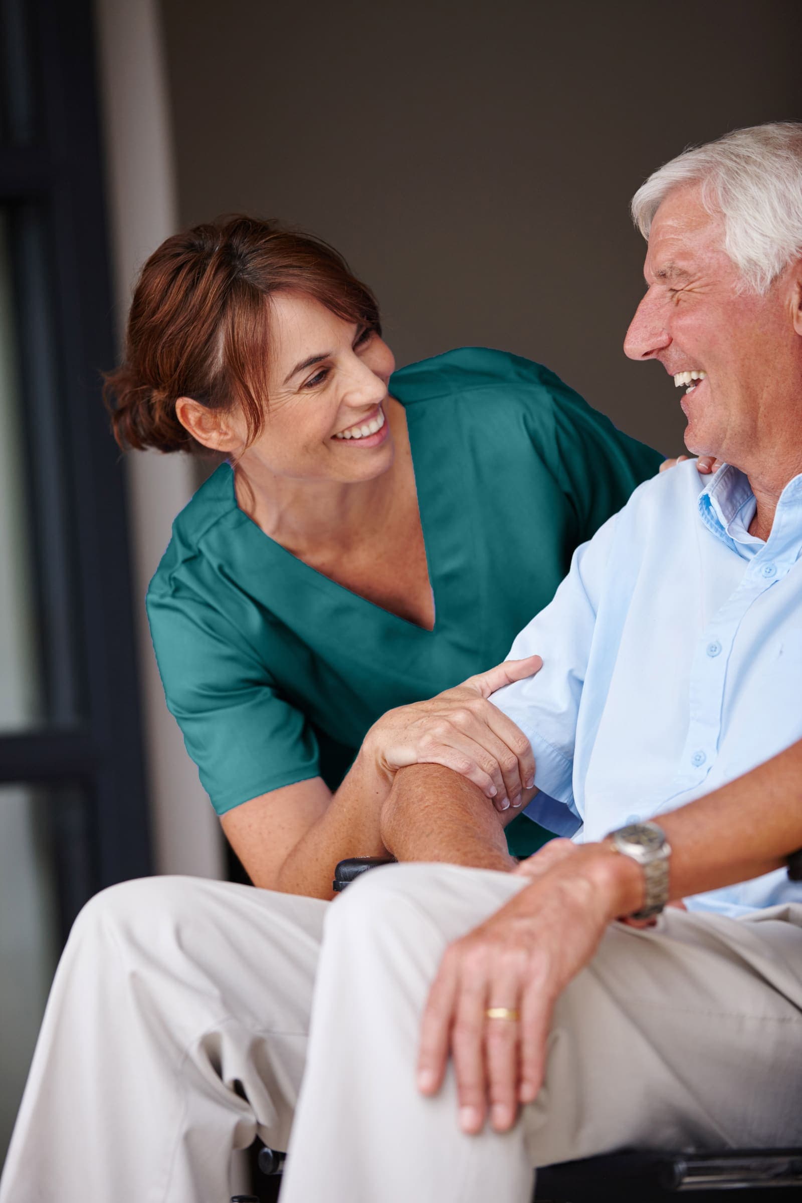 Pflegekraft im Gespräch mit einem Senior